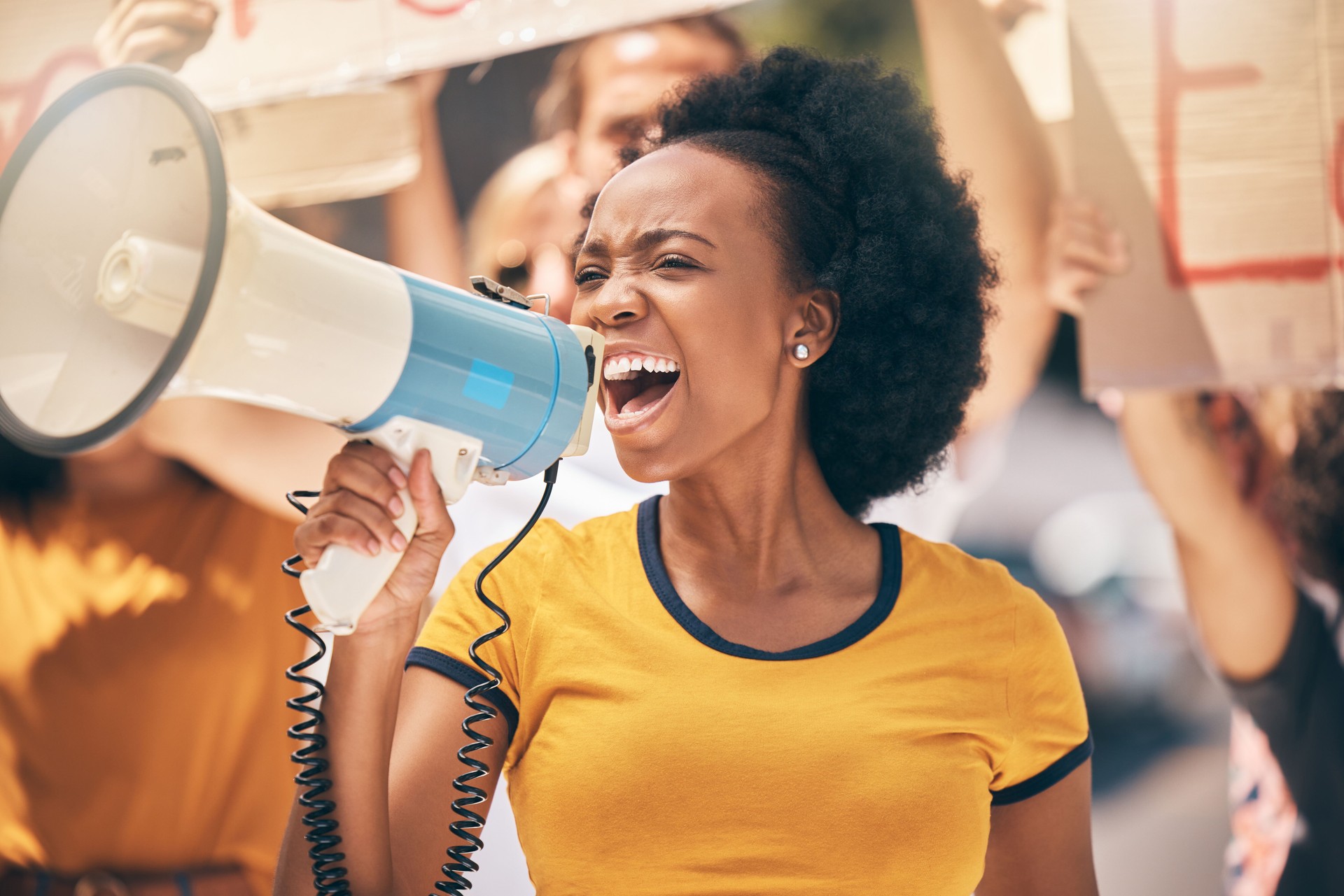 Protest, megaphone and speech of angry black woman at rally. Loudspeaker, revolution and speaking, screaming or shouting leader on bullhorn protesting for human rights, justice and freedom in city.